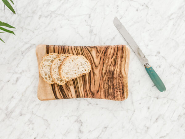 Slices of bread on a cutting board next to a knife