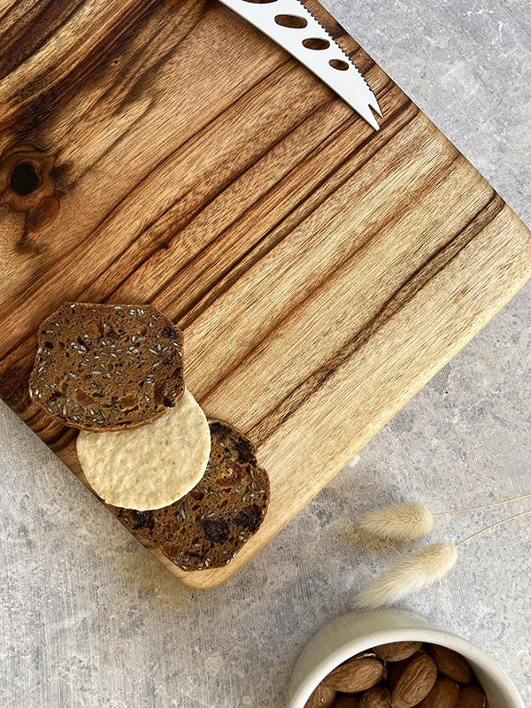 Wooden board with a bowl of almonds