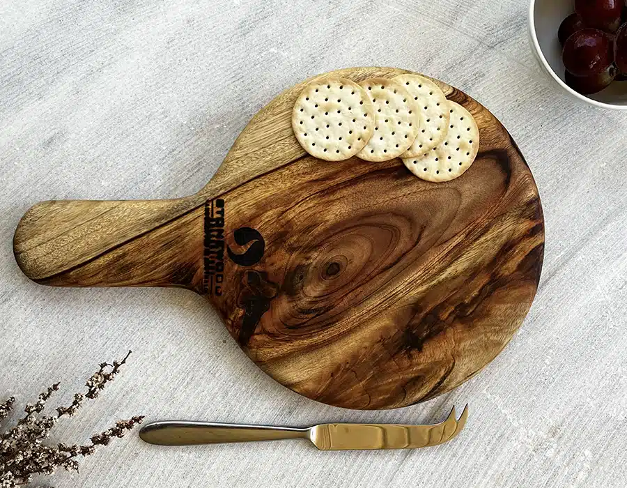 Wooden cutting board with crackers and a knife