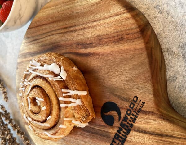 a cinnamon roll on a wooden board