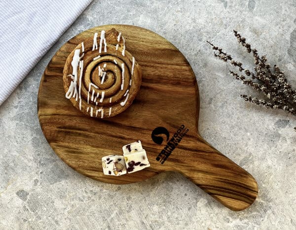 a cinnamon roll on a Stonewood wooden cutting board
